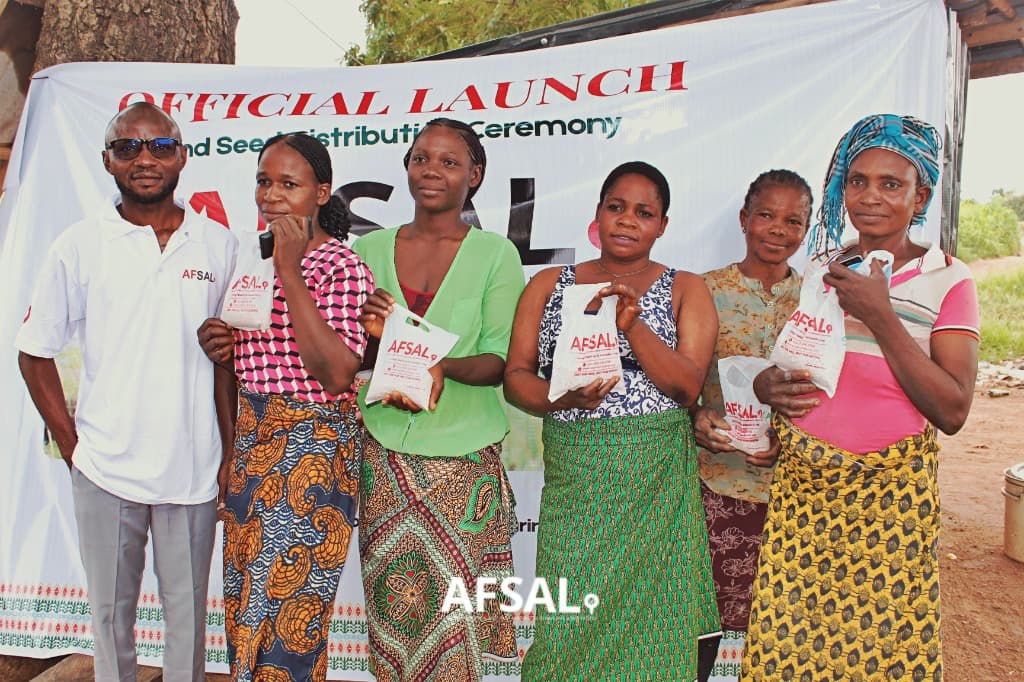 Women smallholder farmers holding improved seed packs